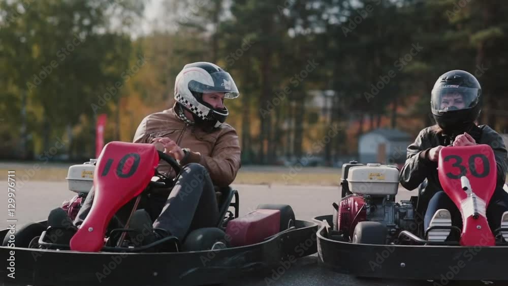 Go-kart track. People racing in karts accidentally hit.