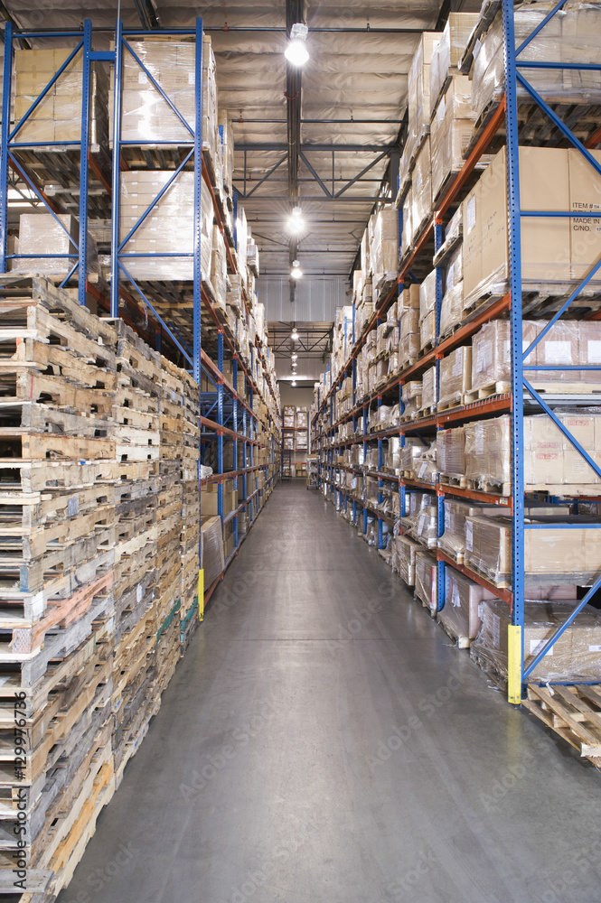Wooden pallets and cardboard boxes stacked in distribution warehouse