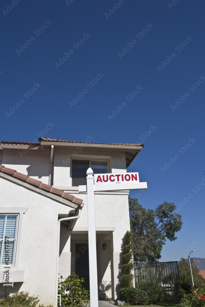 House with 'Auction Sign' against sky