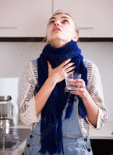 Obraz na plátně woman in scarf gargling throat with domestic soda