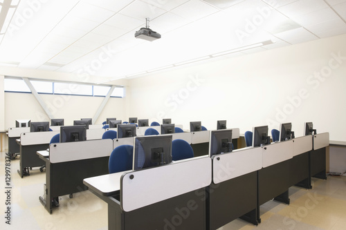 View of empty chairs and computers in rows at seminar room