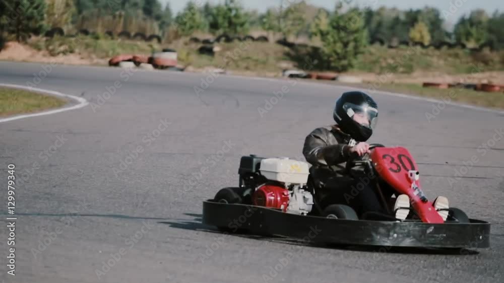 Two drivers on a go-kart track move into the camera and pass it by. Go-kart race. Two drivers on a go-kart track move into the camera and pass it by. Go-kart race.