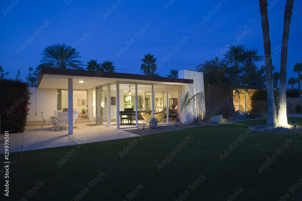 Modern house exterior with silhouette lawn in foreground at night