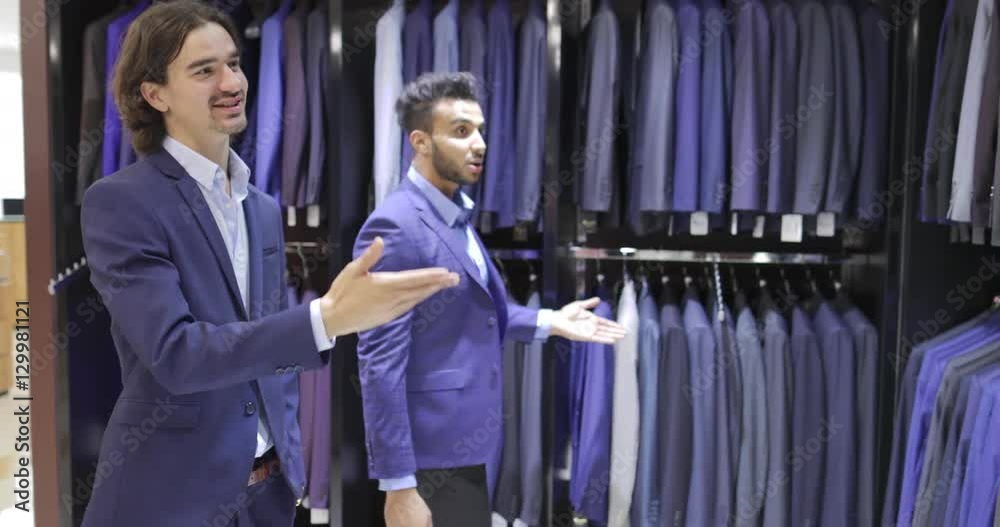 Two Business Man Enter Fashion Shop, Customers Choosing Suit Clothes In Retail Store Young People Shopping Formal Wear Slow Motion 60 Fps Two Business Man Enter Fashion Shop, Customers Choosing Suit Clothes In Retail Store Young People Shopping Formal Wear Slow Motion 60 Fps