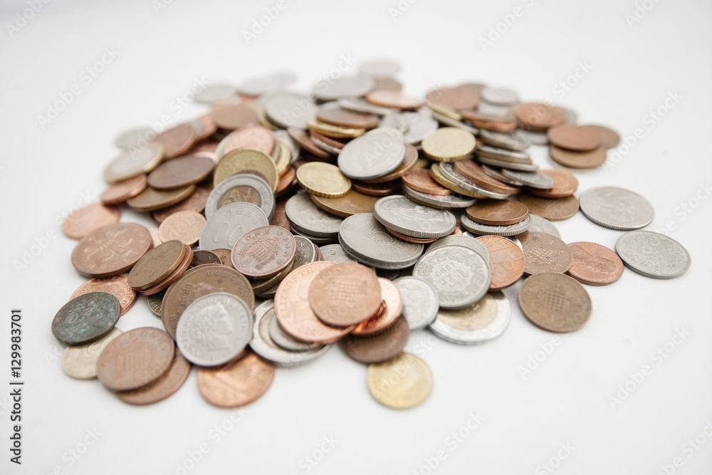 Close-up of large group of coins over white background Close-up of large group of coins over white background