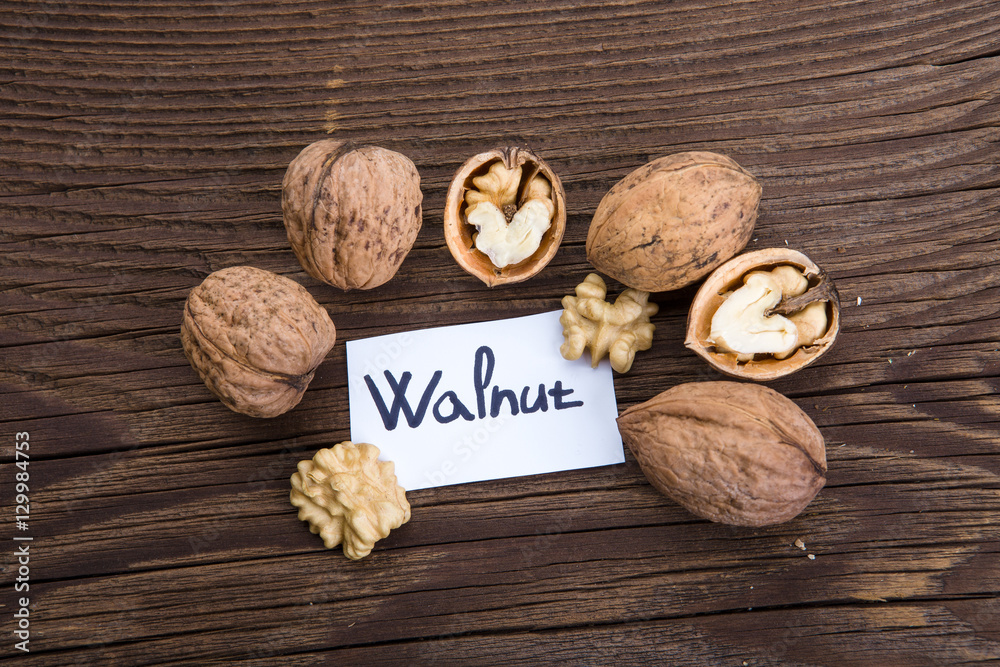 Walnut kernels and whole walnuts on old wooden table