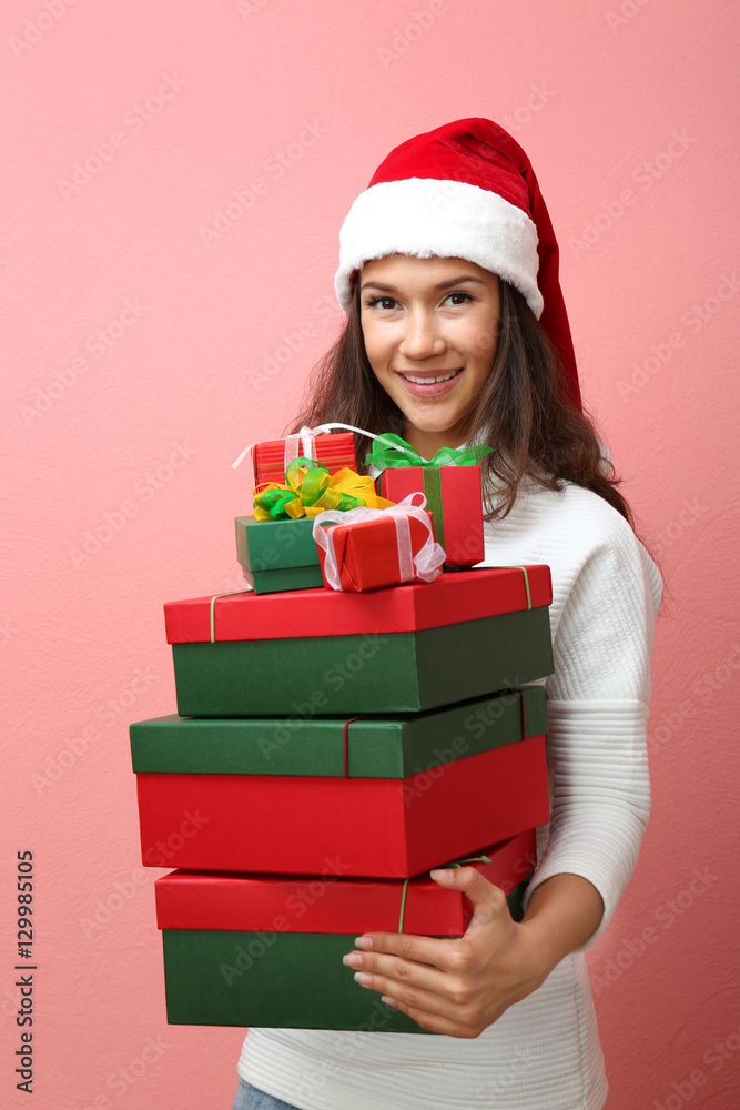 Beautiful happy woman with Christmas gifts on pink background Beautiful happy woman with Christmas gifts on pink background