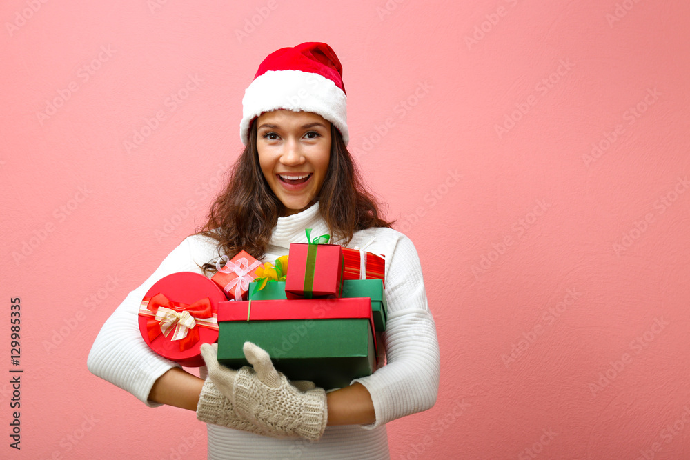 Beautiful happy woman with Christmas gifts on pink background Beautiful happy woman with Christmas gifts on pink background