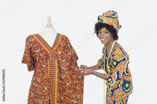 Portrait of an African American female fashion designer working on dashiki over gray background