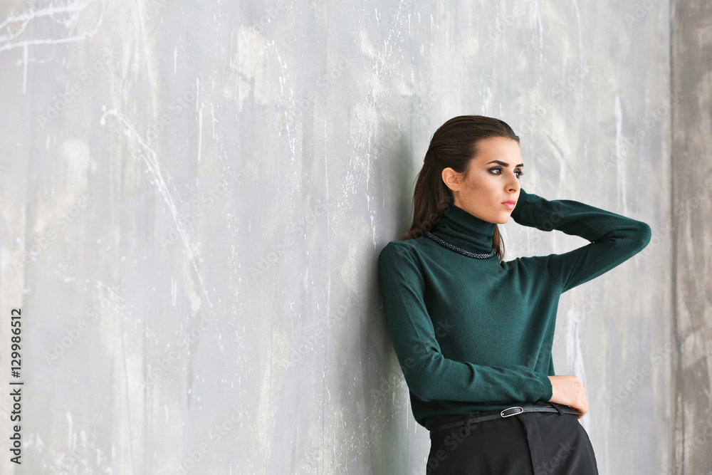 Beautiful woman in fashion clothes on grunge wall background Beautiful woman in fashion clothes on grunge wall background