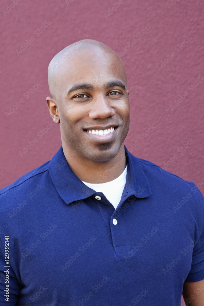 Portrait of a happy bald African American male over colored background Portrait of a happy bald African American male over colored background