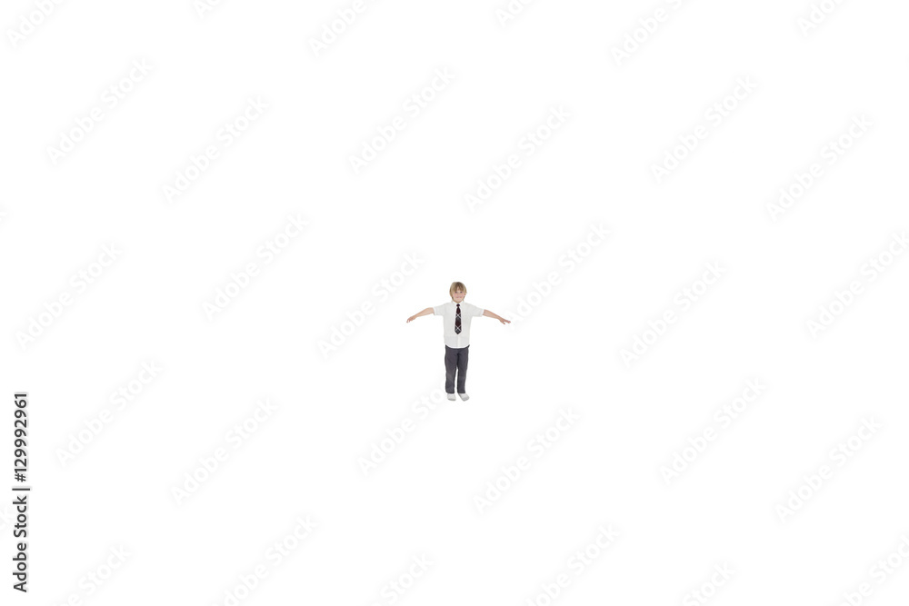 Elementary boy standing at distance with arms outstretched over white background