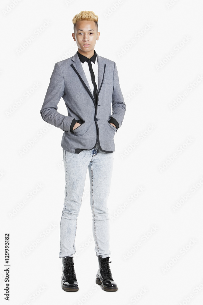 Portrait of a teenage boy standing in smart casuals over gray background Portrait of a teenage boy standing in smart casuals over gray background