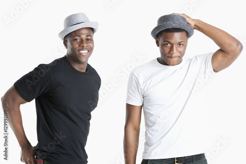 Portrait of happy young African American men wearing hats over gray background