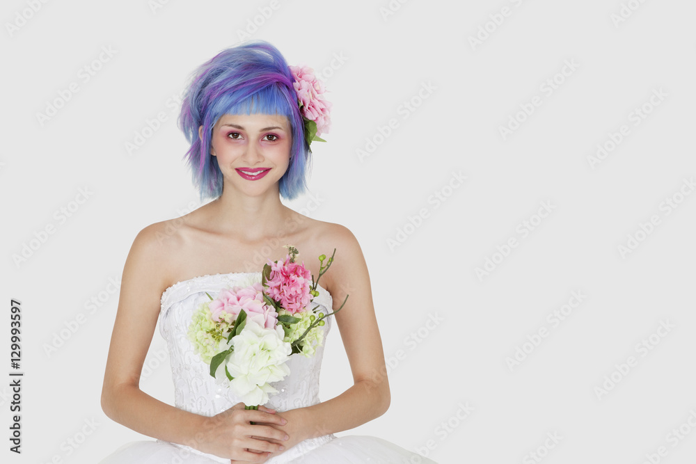 Portrait of happy young woman in wedding dress with dyed hair against gray background Portrait of happy young woman in wedding dress with dyed hair against gray background