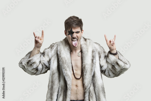 Картината върху платно Portrait of an angry young man making rebellious gestures and sticking out tongu