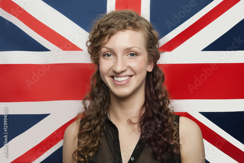 Portrait of happy young woman against British flag