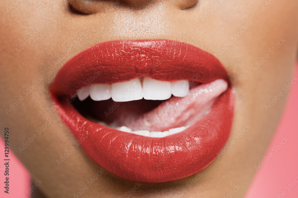 Cropped image of woman licking red lipstick Cropped image of woman licking red lipstick