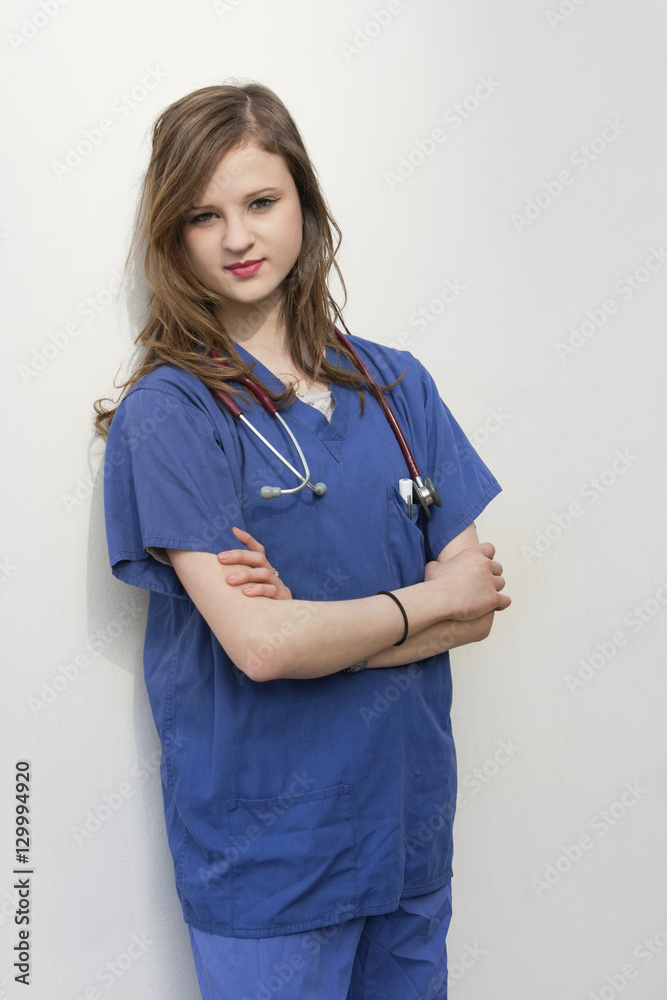 Portrait of a female surgeon standing with arms crossed over colored background Portrait of a female surgeon standing with arms crossed over colored background