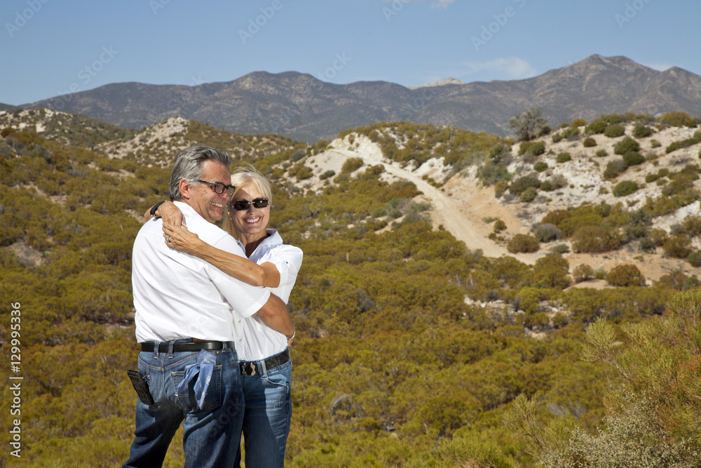 Senior couple hug with desert in background