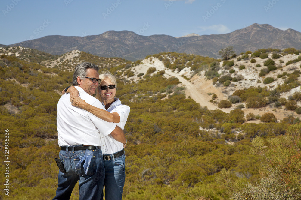 Senior couple hug with desert in background Senior couple hug with desert in background