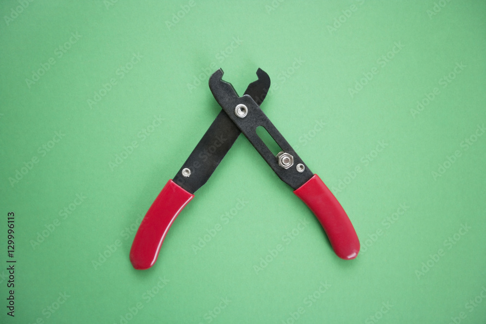 Close-up view of duckbill pliers over green background Close-up view of duckbill pliers over green background