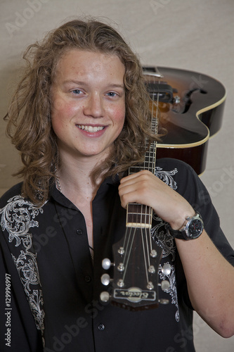 Portrait of smiling young musician with guitar