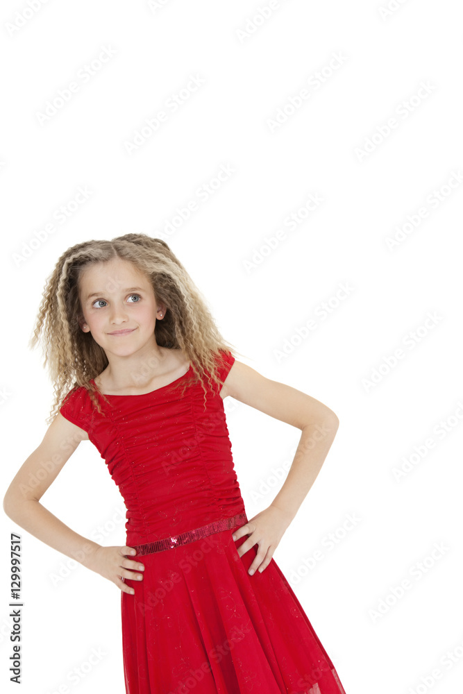 Tilt image of girl wearing red frock looking sideways with hands on hips over white background