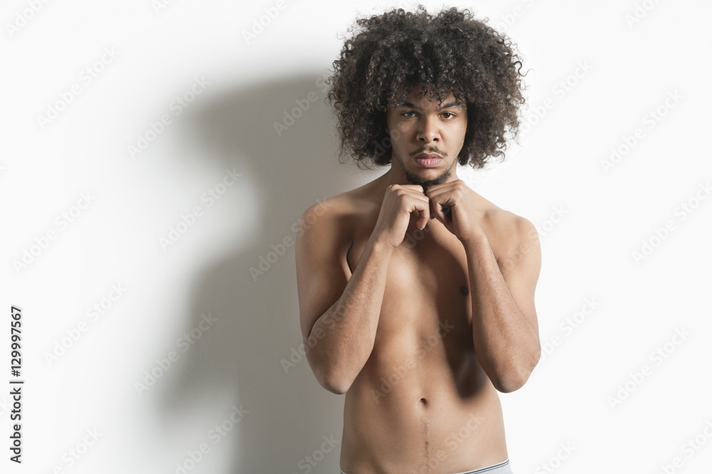 Portrait of young man with fist standing over white background Portrait of young man with fist standing over white background