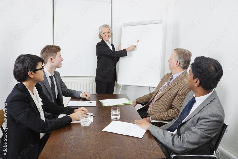Senior woman using whiteboard in business meeting Senior woman using whiteboard in business meeting