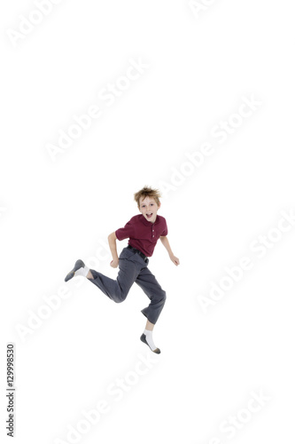 Portrait of cheerful pre-teen boy jumping over white background