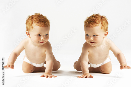 Obraz na plátne Identical ginger twins looking at each other in studio