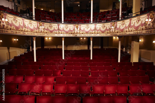 View of an empty theatre with red seats and balcony