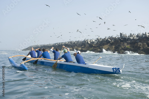 Rear view of multiethnic outrigger canoeing team heading to race stage