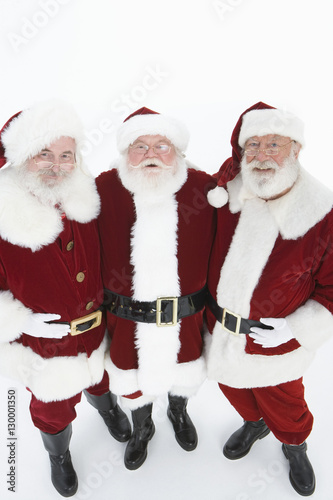 Portrait of three happy men in Santa Claus costumes isolated over white background