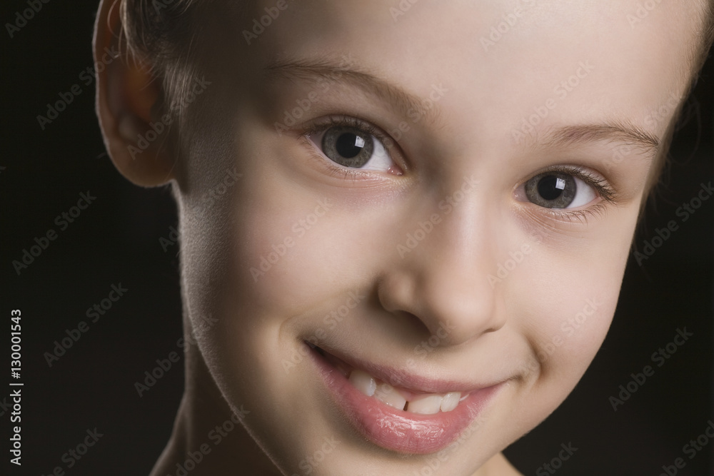 Closeup portrait of happy young girl on black background Closeup portrait of happy young girl on black background