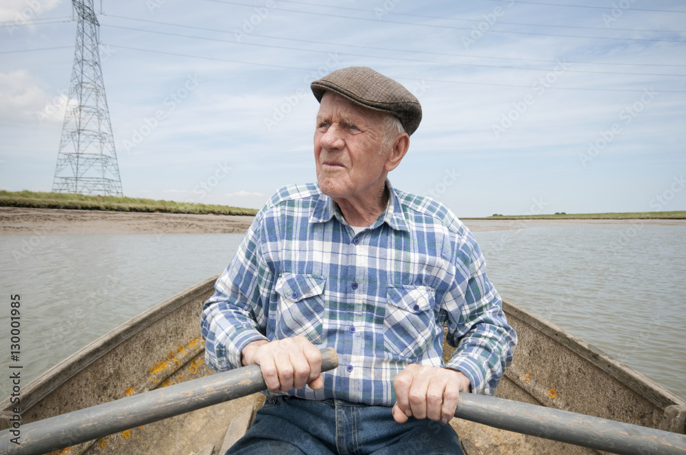 Senior man rowing a boat on a reservoir