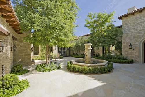 View of courtyard with fountain and trees on a sunny day