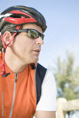 Closeup of handsome male cyclist wearing helmet and sunglasses