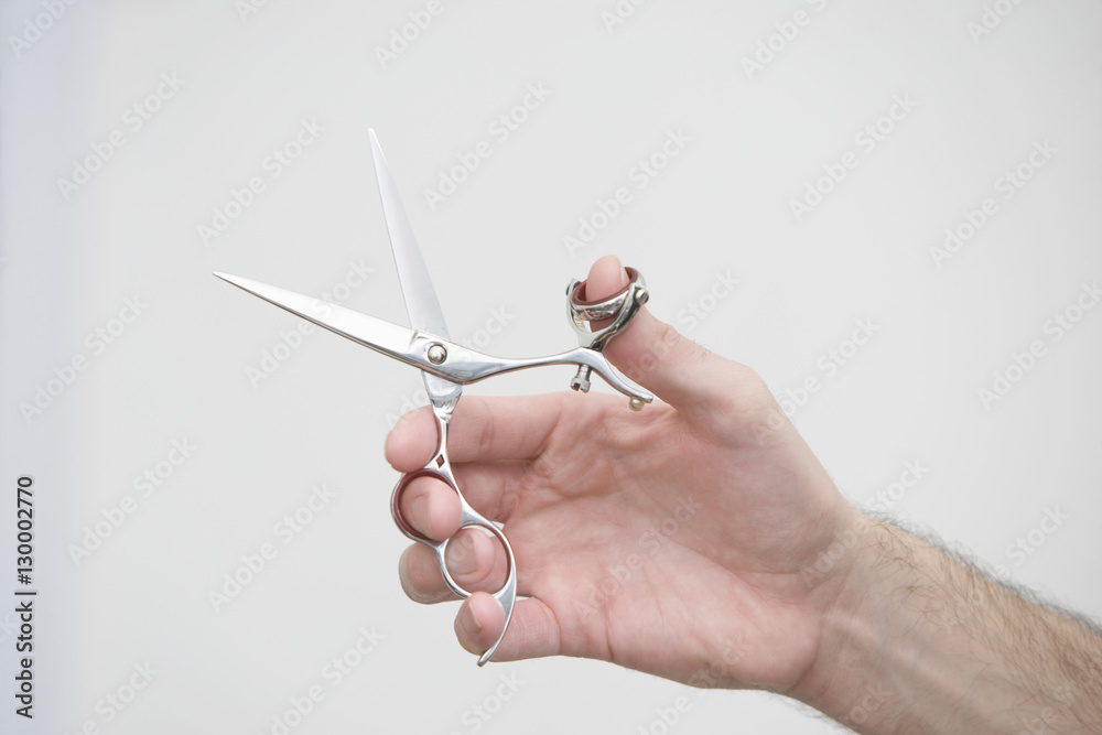 Cropped image of male hairdresser holding scissors in beauty salon Cropped image of male hairdresser holding scissors in beauty salon