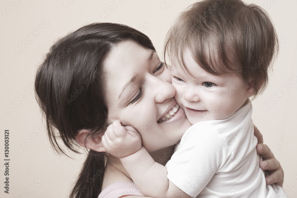 Closeup of happy mother hugging baby girl over colored background Closeup of happy mother hugging baby girl over colored background