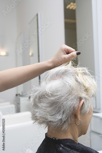 Closeup side view of senior woman getting her hair done in salon
