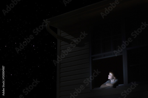 Photography Young boy at open window looking at night sky