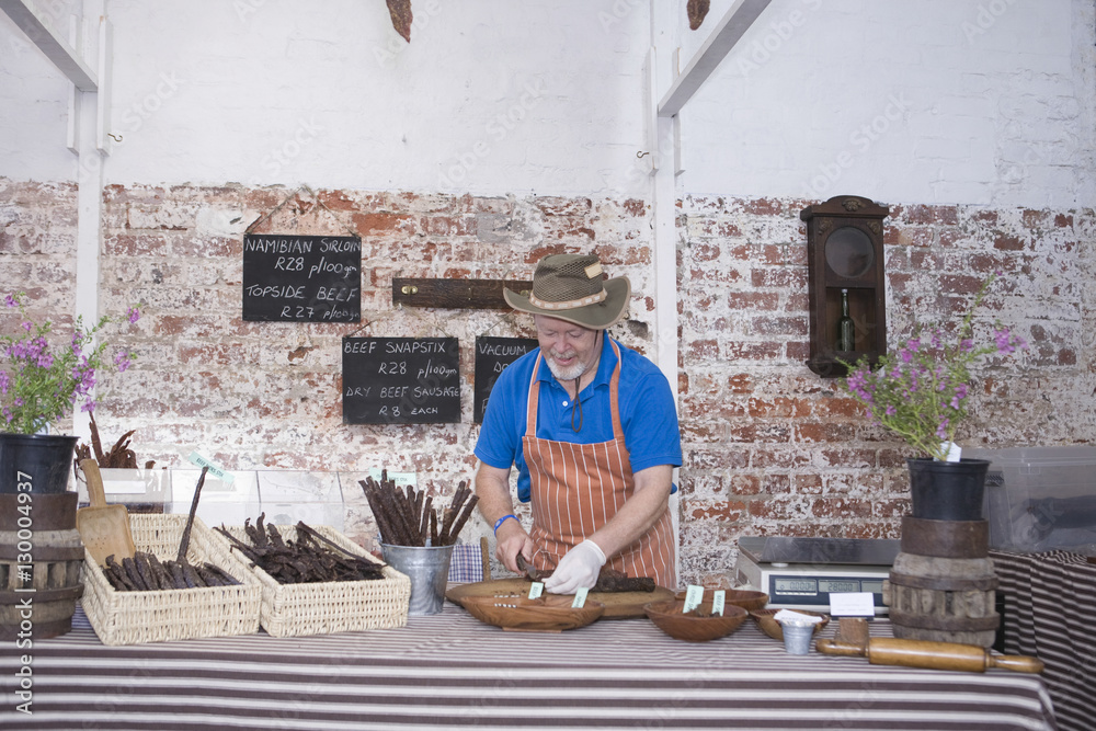 Caucasian man preparing speciality sausages in shop Caucasian man preparing speciality sausages in shop