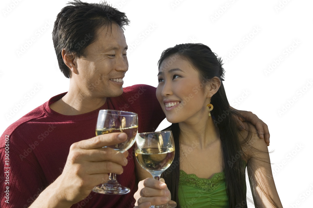 Happy mid-adult couple clinking their wineglasses against white background Happy mid-adult couple clinking their wineglasses against white background