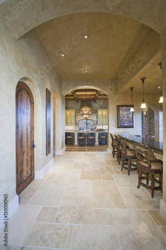 Tiled floor along stools at island with arched ceiling in the kitchen © moodboard