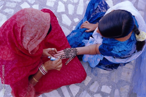 Woman's hand being decorated with henna design, Rajasthan photo