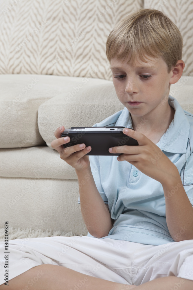 Young boy playing games on PSP at home Young boy playing games on PSP at home