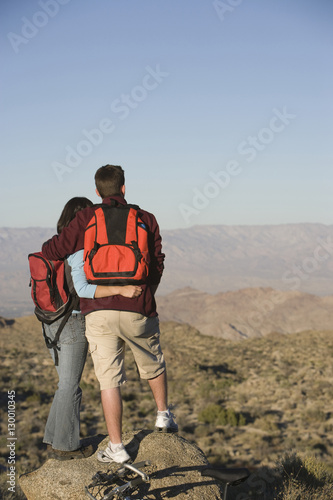 Rear view of couple looking at view while standing together on a rock