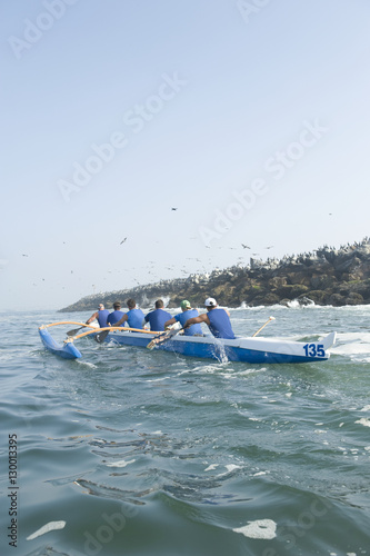 Rear view of multiethnic outrigger canoeing team heading to race stage
